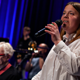 Pige synger i mikrofon